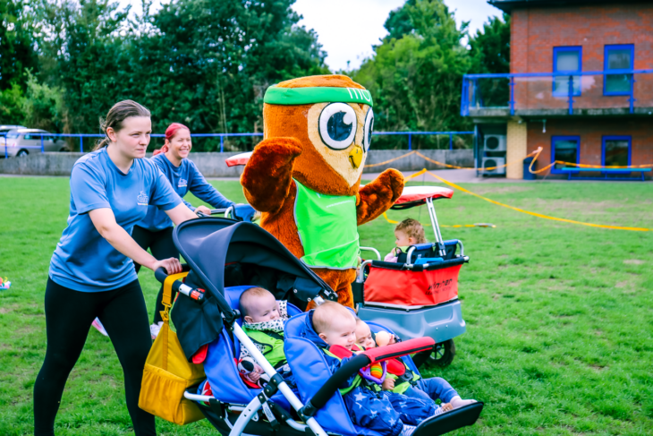 Nursery staff and children in buggies take part in Move for Momentum, a fundraising walk