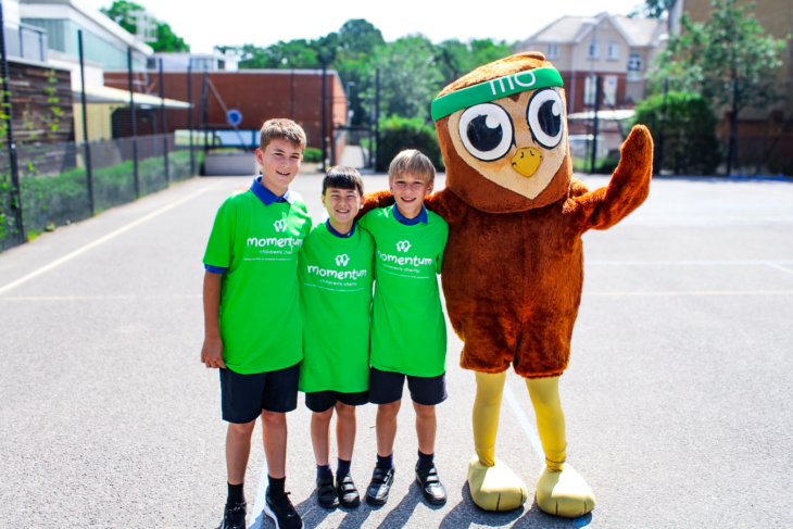Three students from Marshgate Primary in Momentum t-shirts with Mo the Owl