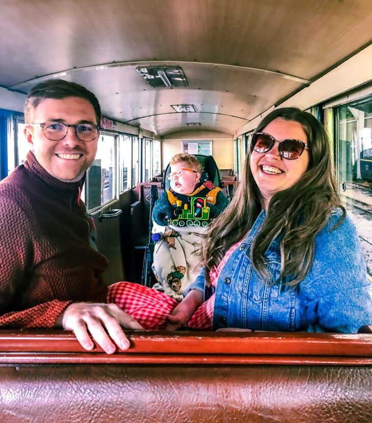 A mother and father with their son on board a steam train