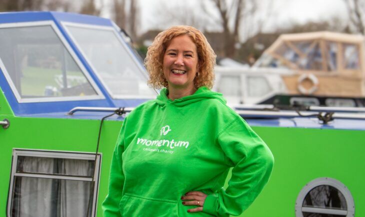 Sarah Woods, CEO at Momentum Children's Charity standing by Momentum's boat