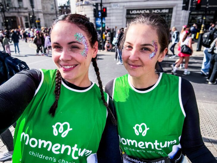 Two female runners with brown hair wear their Momentum running vests at the London Landmarks Half Marathon